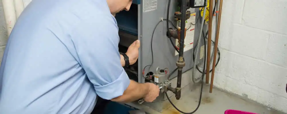 Furnace repair technician inspecting and servicing a home heating system in Boulder, CO