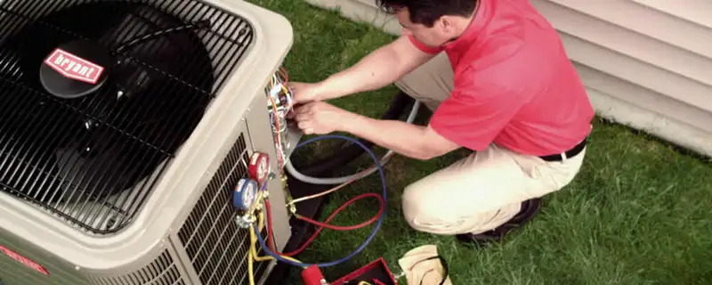 HVAC technician servicing an outdoor air conditioner unit in Boulder, CO