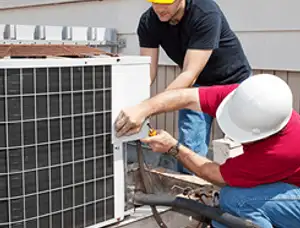 HVAC technicians repairing an outdoor AC unit on a rooftop in Boulder, CO