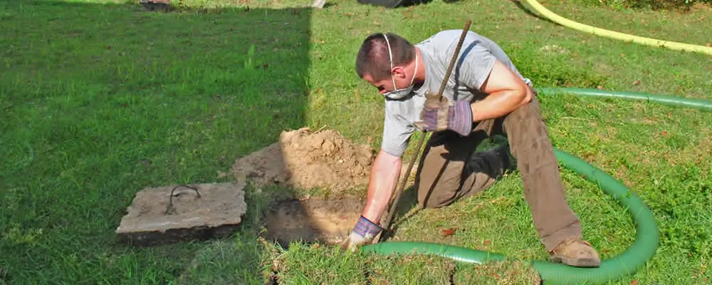 Septic pumping technician servicing a residential septic tank in Boulder, CO